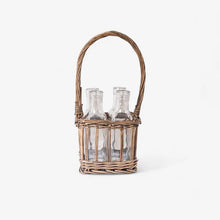 Wicker basket with glass bottles on a white background