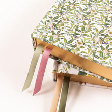 Floral-patterned fabric with colorful ribbons on a white background