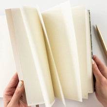 Person holding a notebook with a pen on a white background