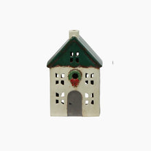 Decorative house-shaped lantern with a green roof and wreath on a white background