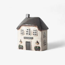 Small ceramic house model with 'Patisserie' sign on a white background