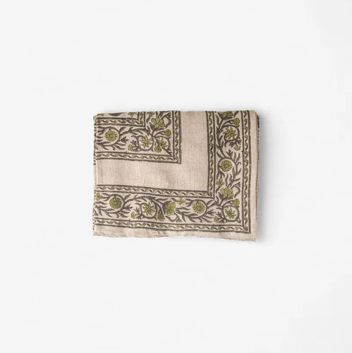 Folded fabric with intricate green patterns on a white background