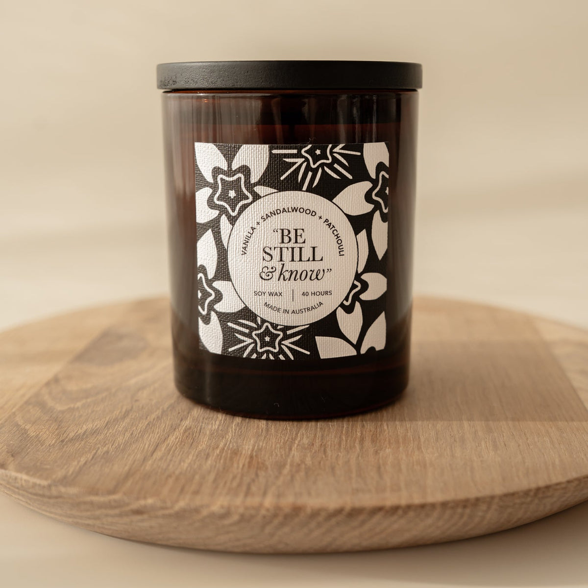 Well Versed Homes Candle out of box with black timber lid sitting on wooden board