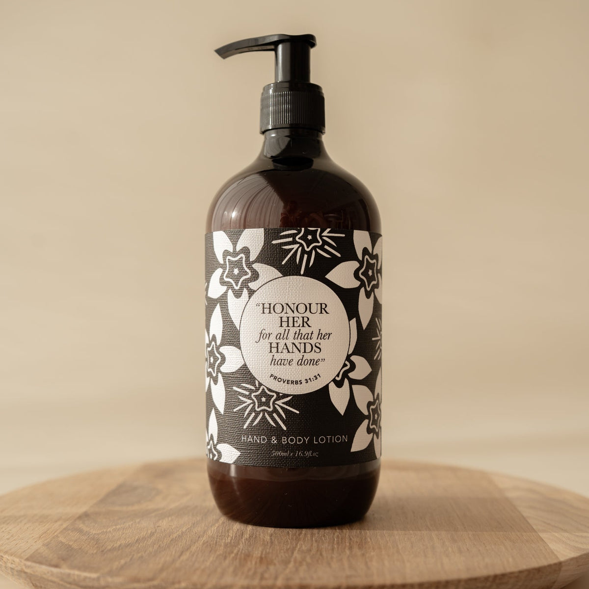 Well Versed Homes Signature Hand and Body Lotion on wooden board with Bible Verse from Provers on the label