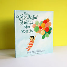 Book titled 'The Wonderful Things You Will Be' with a child holding balloons on a yellow background