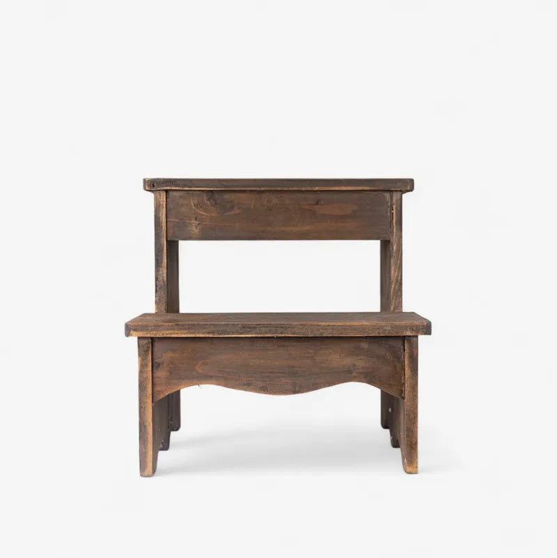 A rustic two-step wooden stool with a dark brown finish and handcrafted details, shown against a plain white background.