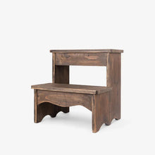 A rustic two-step wooden stool with a dark brown finish, featuring a small top step and a lower step with an arched opening, set against a plain light gray background.