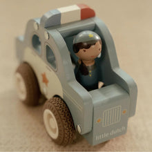 Toy police car with a figure of a policeman on a beige background