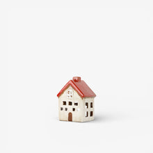 Small ceramic house with a red roof on a white background
