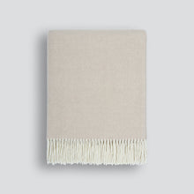 Beige blanket with white fringe on a light gray background
